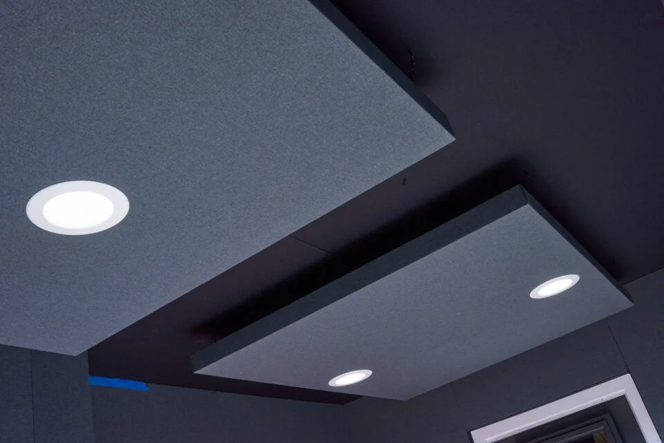 Acoustical ceiling cloud panels with recessed lighting inside a sound studio trailer.